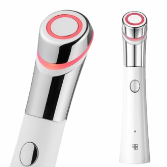 White handheld facial massage device with a chrome top and glowing ring.