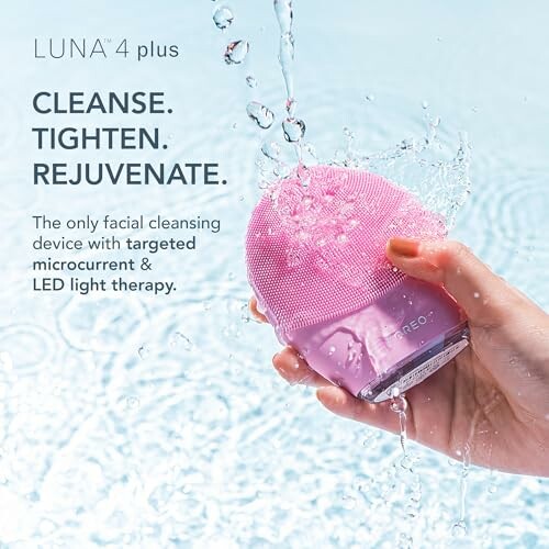 Pink facial cleansing device with water splashes.